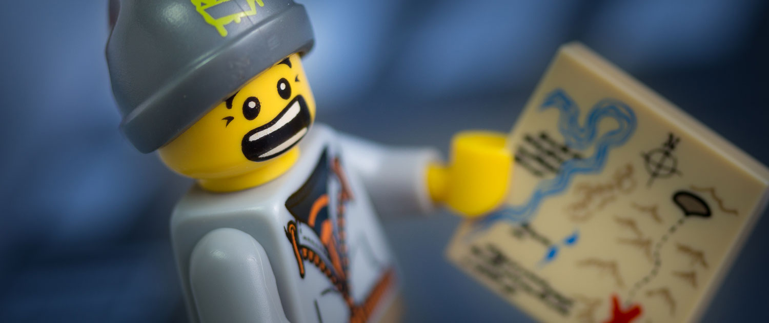 Photograph of a LEGO minifigure holding a map and looking worried