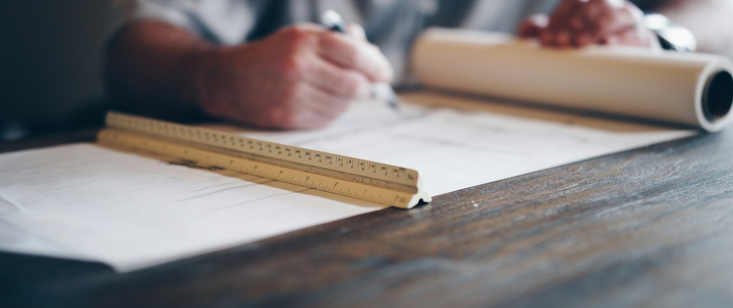 A person drafting on a blueprint.